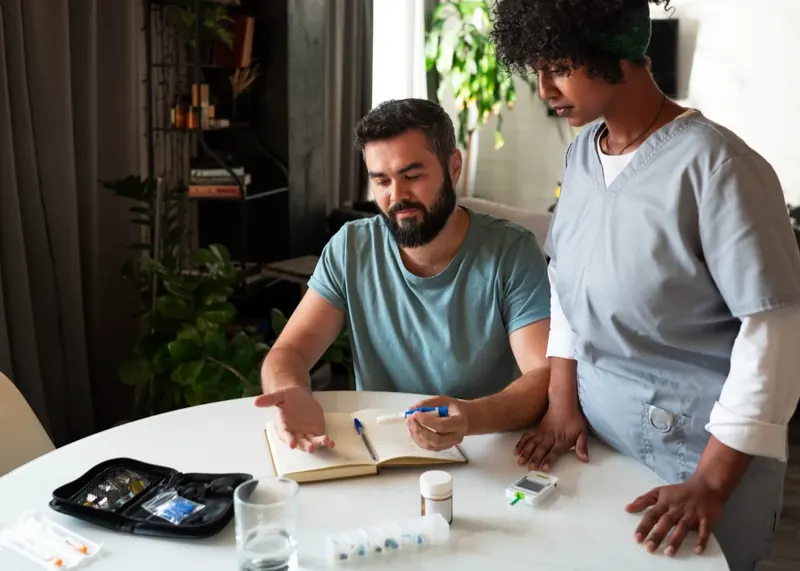 Nurse reviewing medication and glucose monitoring routine with a client during a psychiatric medication management session in Central Florida