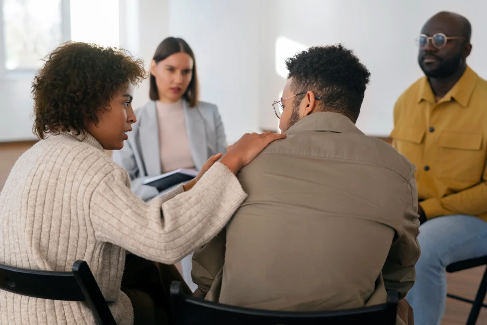 Woman comforting a man during a coordinated psychiatric rehabilitation session at BCSS in Orlando FL