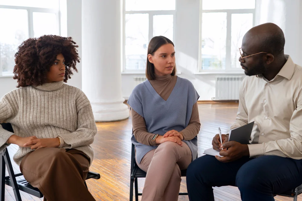 Mental health specialist conducting an intake assessment during a group therapy session at Bridges Community, inc