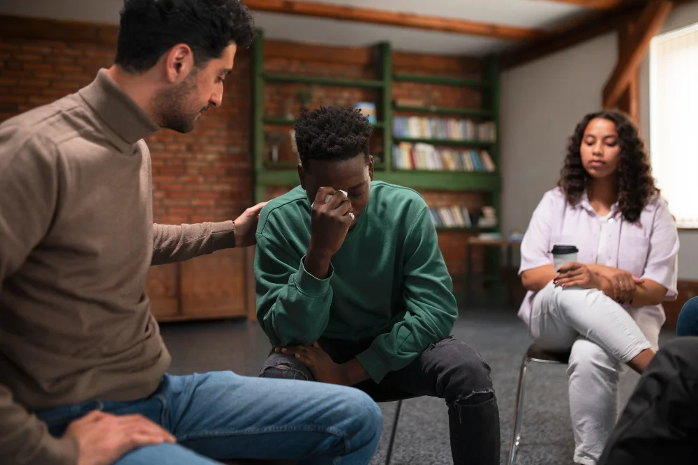Therapist comforting a young man at a BCSS mental health trauma support group in Orlando FL